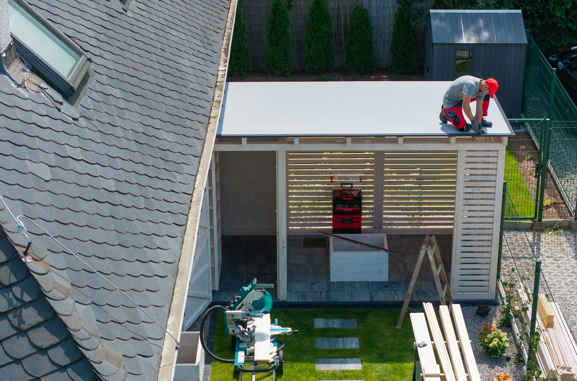 Worker Installing Roof On Patio Structure